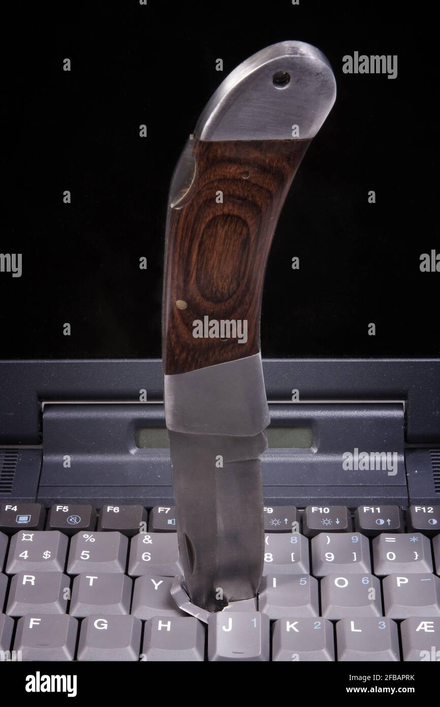 A knife stuck in a laptop keyboard Stock Photo Alamy