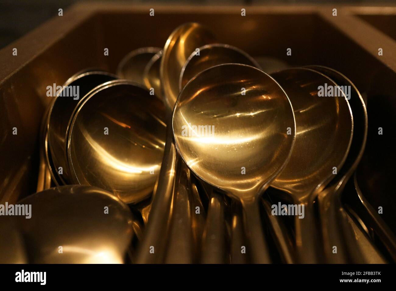 Shiny brass spoons in a pile Stock Photo