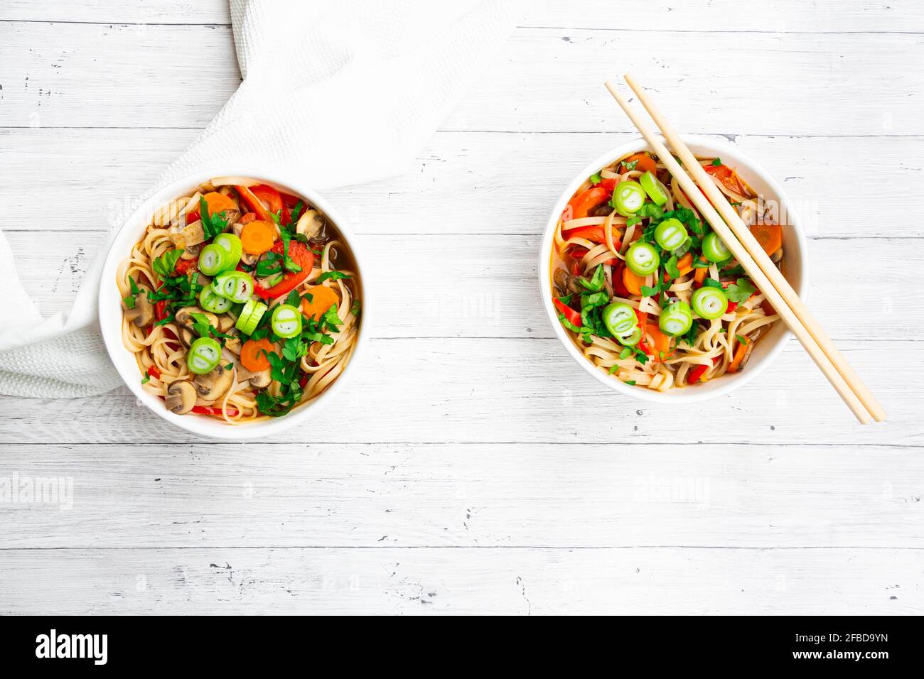 Asian noodle soup with rice noodles, bell pepper, mushrooms, spring onions, coriander and carrots Stock Photo