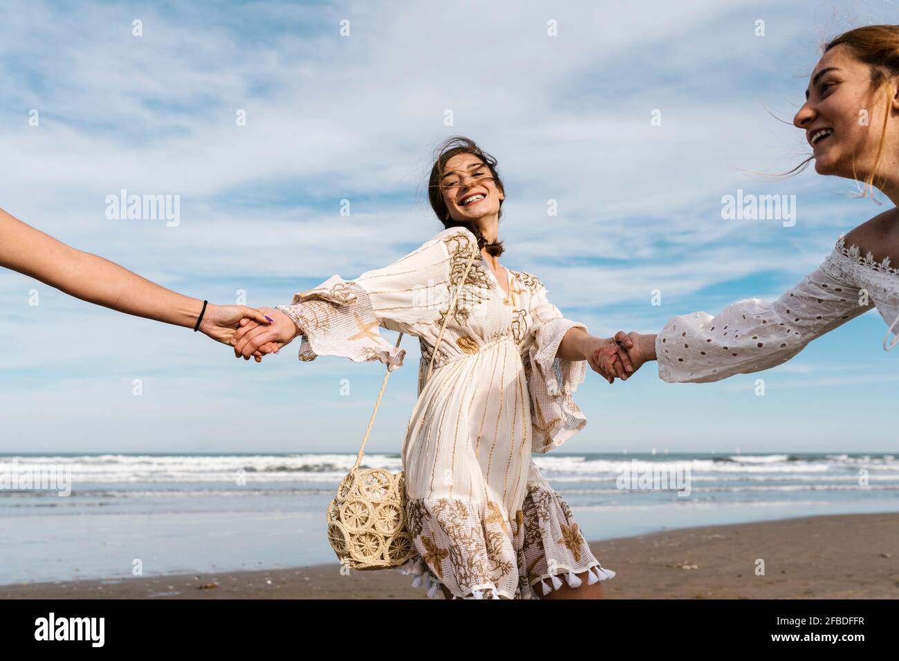 Woman on beach holding hands hi-res stock photography and images - Alamy