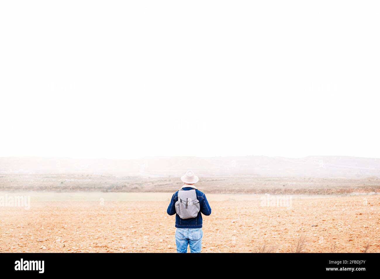 Man with back pack standing in front of sky Stock Photo