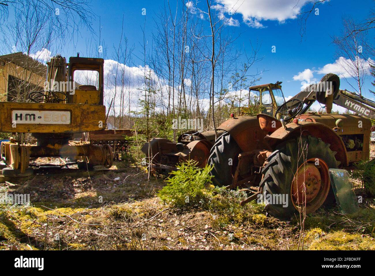 Junkyard tractors and Hymac excavator Stock Photo