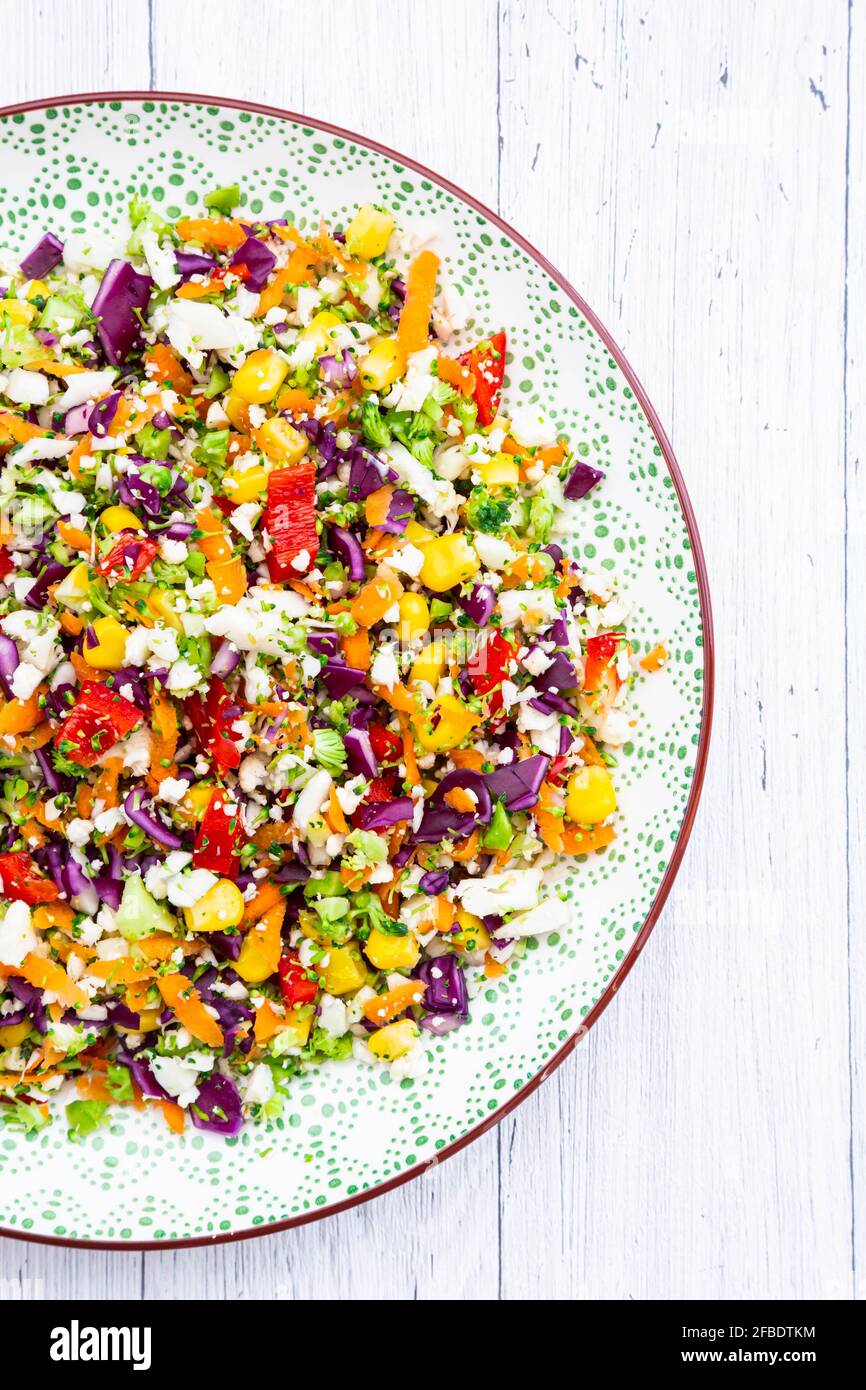 Rainbow salad made out of broccoli, carrot, corn, cauliflower, red cabbage, red bell pepper Stock Photo