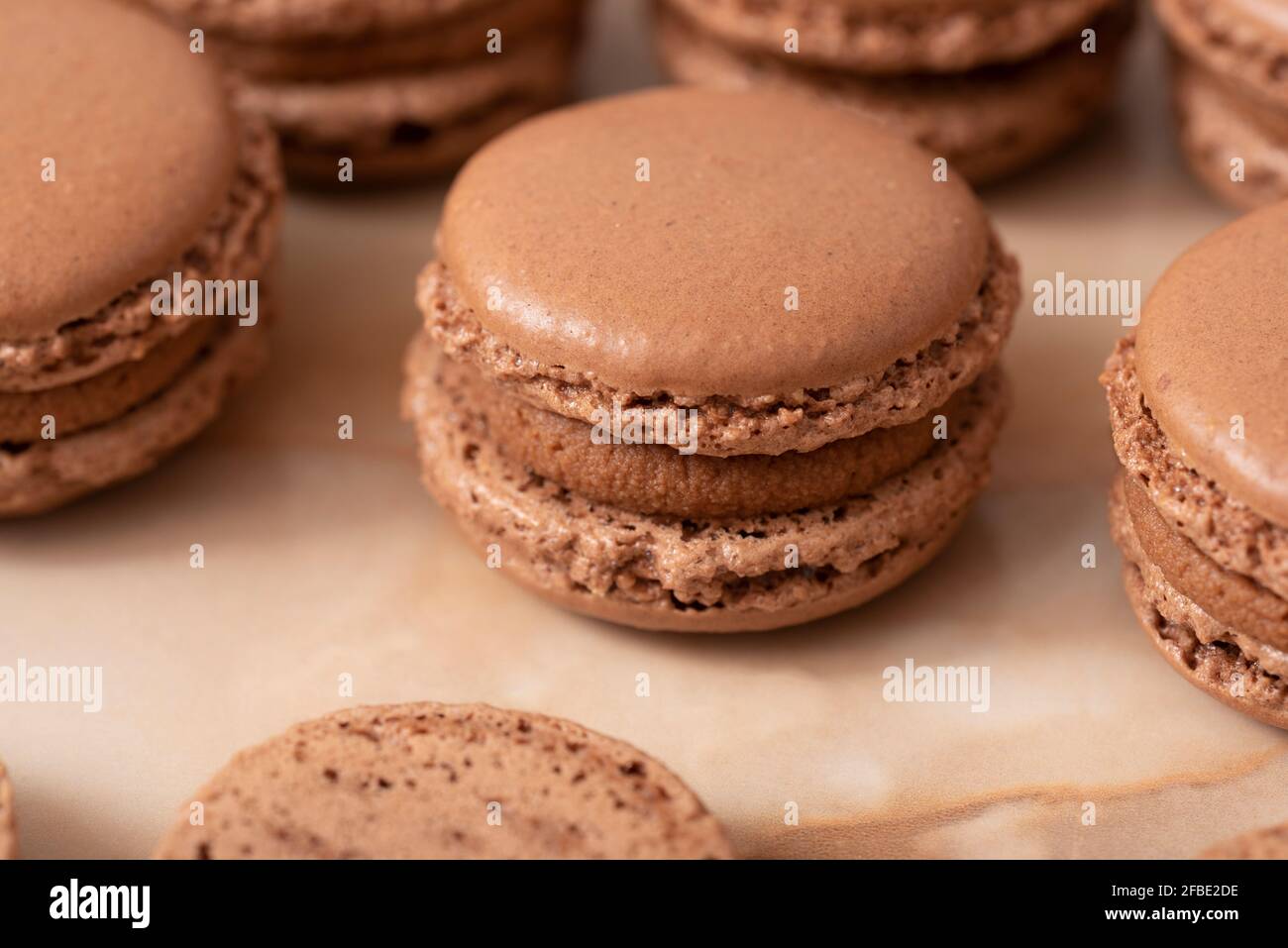 brown macarons with chocolate cream, on a wooden table Stock Photo