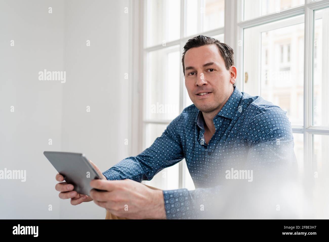 Male entrepreneur using digital tablet at workplace Stock Photo