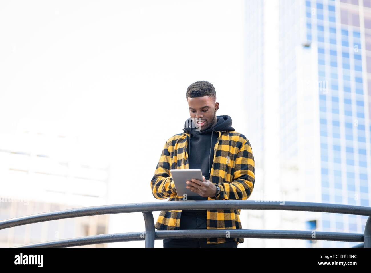 Young man using digital tablet at railing Stock Photo