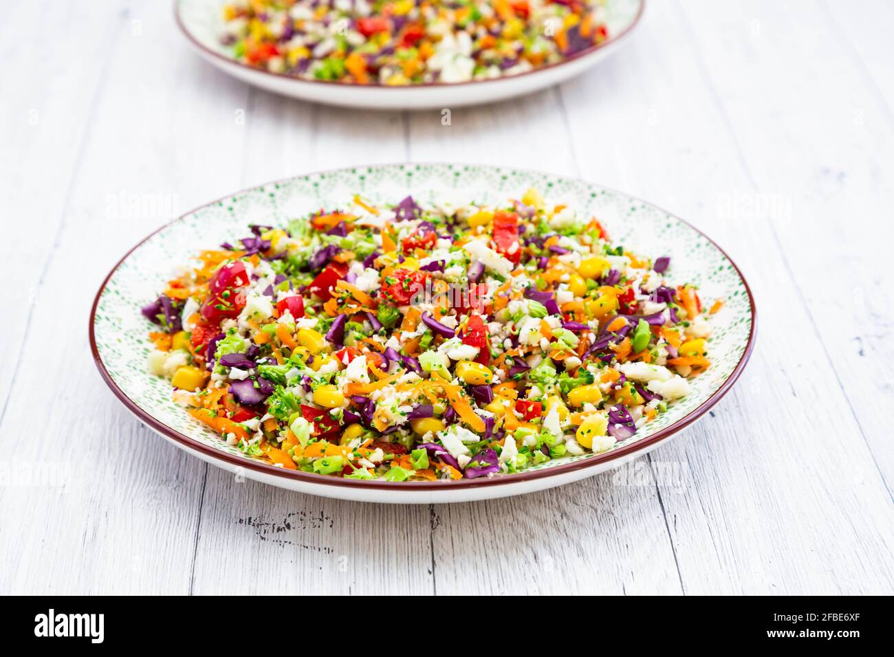 Rainbow salad made out of broccoli, carrot, corn, cauliflower, red cabbage, red bell pepper Stock Photo