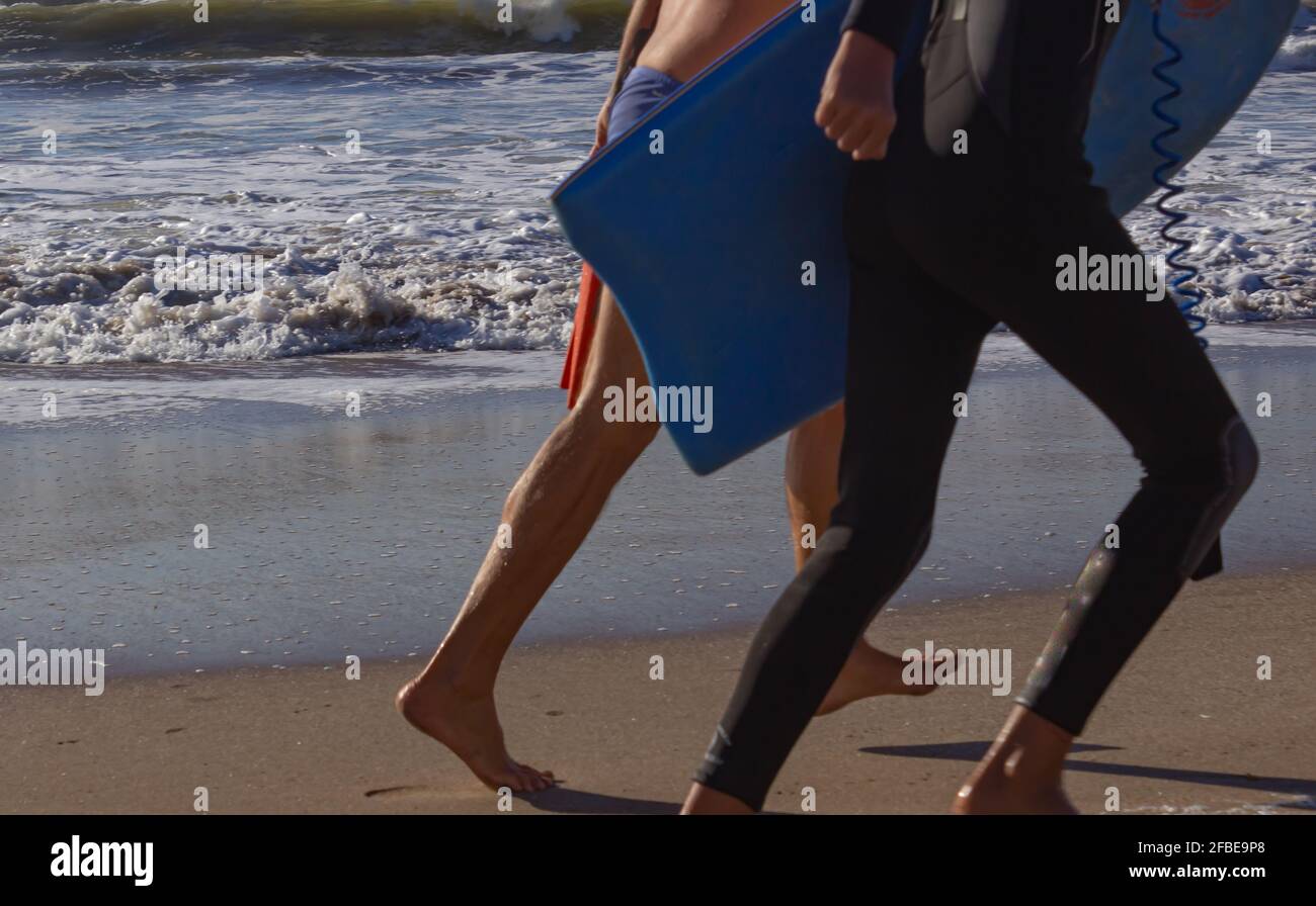 Surfer on the beach on a sunny day. Stock Photo