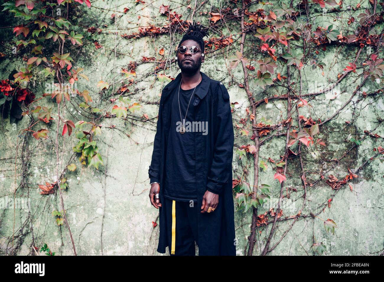 Young fashionable man standing in front of wall Stock Photo - Alamy