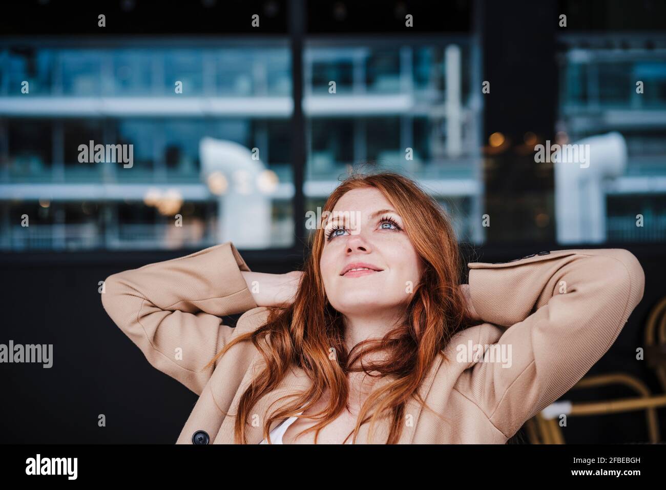 Contented woman day dreaming while sitting at cafe Stock Photo