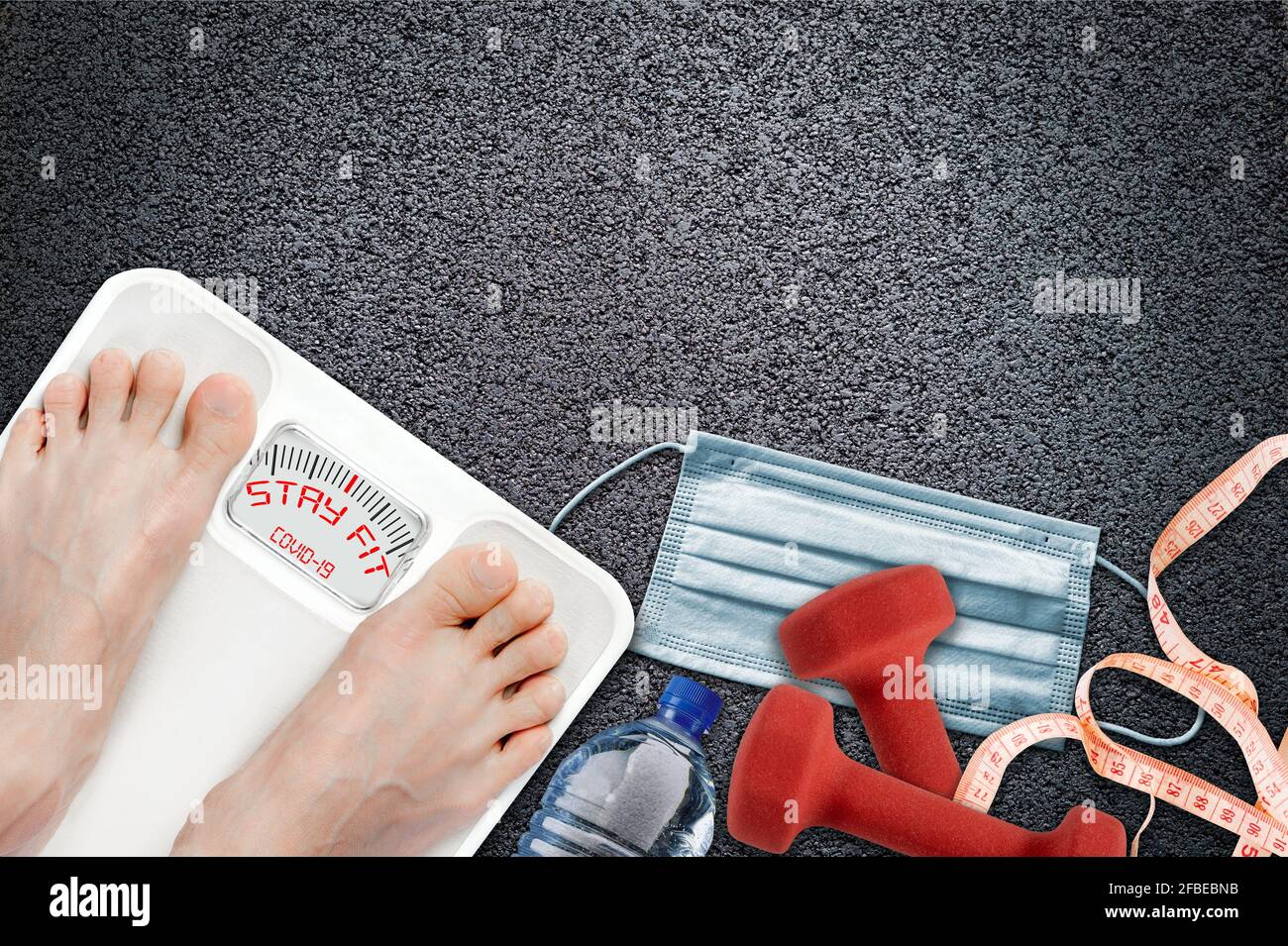 Woman on bathroom scale with Stay Fit message during COVID-19 quarantine. Concept of healthy lifestyle and sport exercise during self isolation surrou Stock Photo