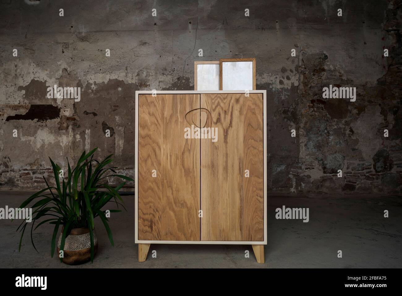 Blank picture frames standing on top of brown wooden cupboard Stock Photo