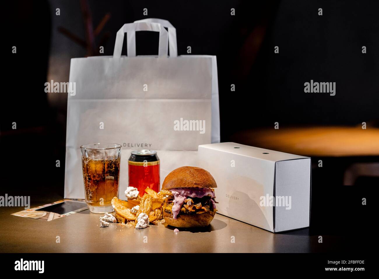 Food and drink arranged by paper bag and box on kitchen island Stock Photo
