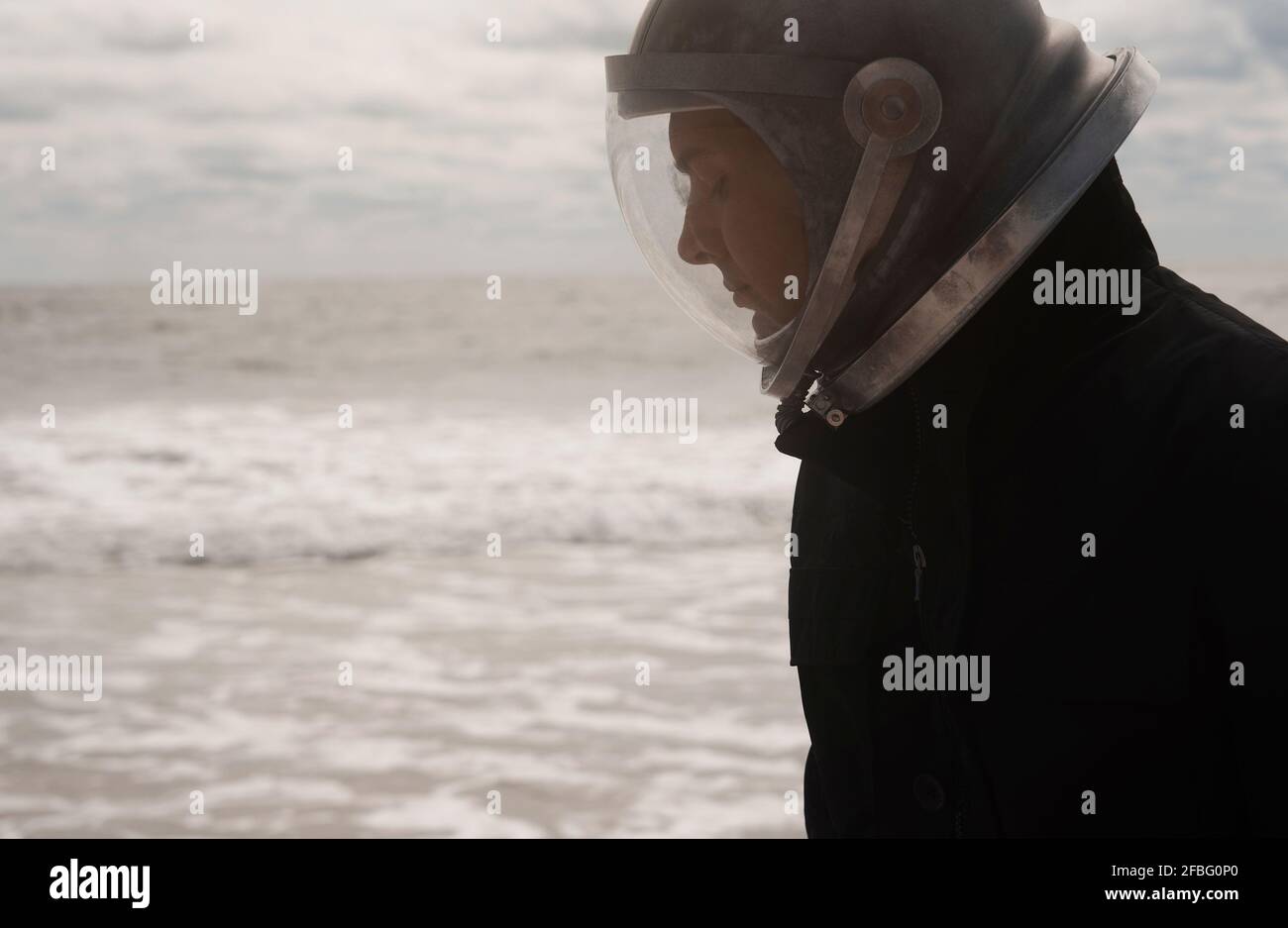 Astronautic man in space helmet at beach Stock Photo
