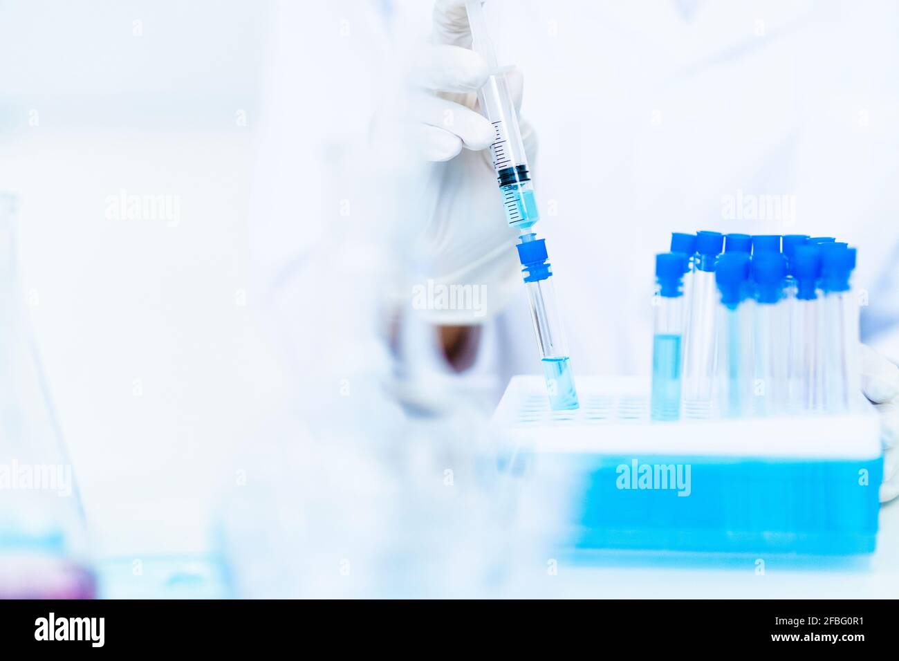 Researcher injecting liquid in test tube at laboratory Stock Photo