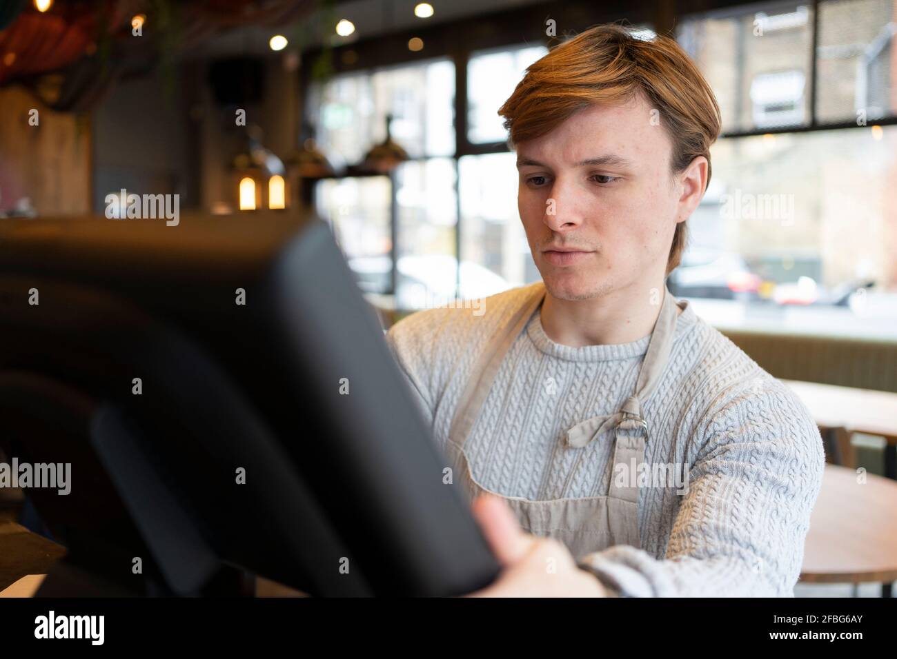 Businessman adjusting restaurant computer during day Stock Photo