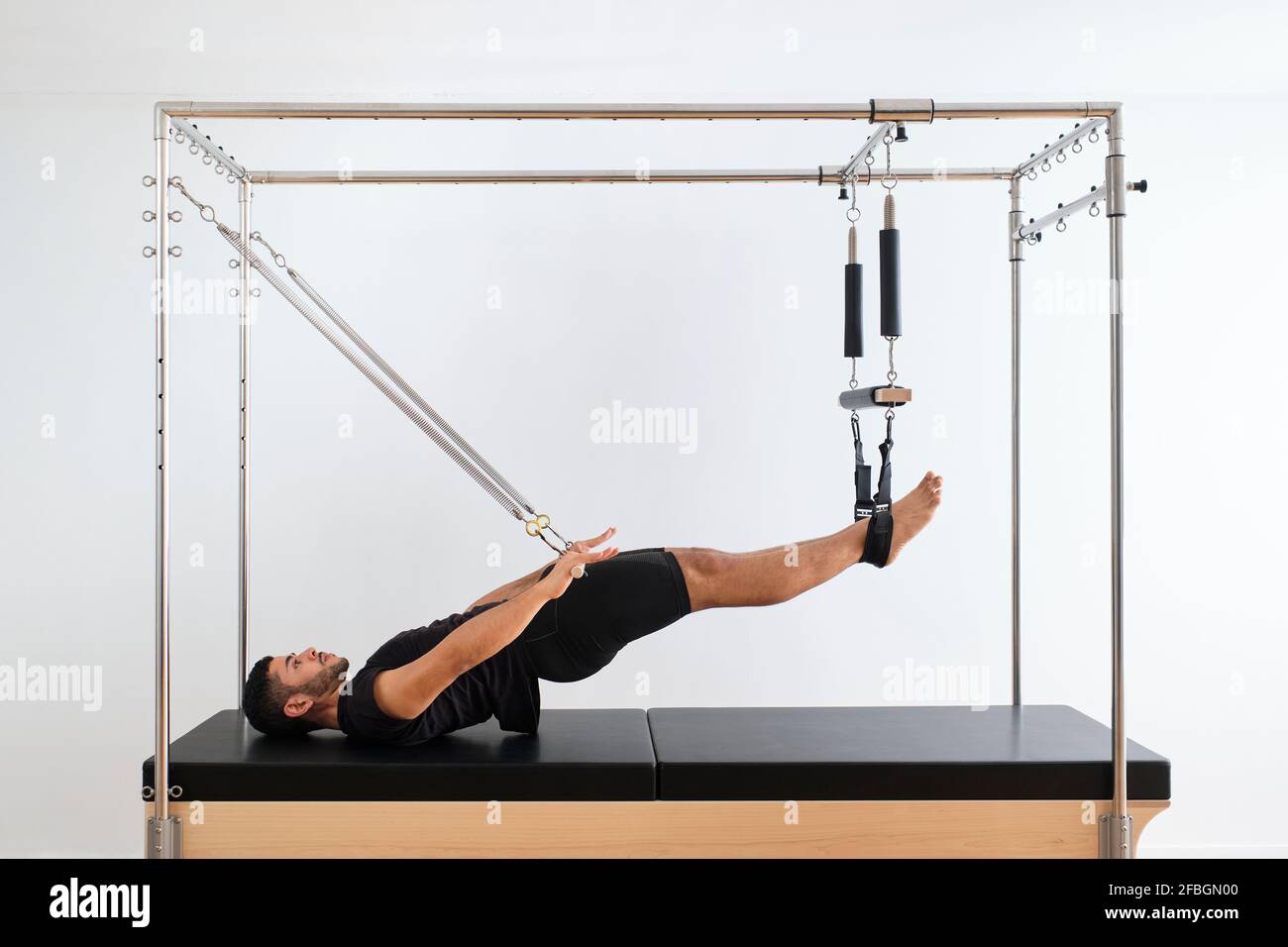 Young slim caucasian female resting on bar of pilates cadillac reformer  Stock Photo by StudioVK