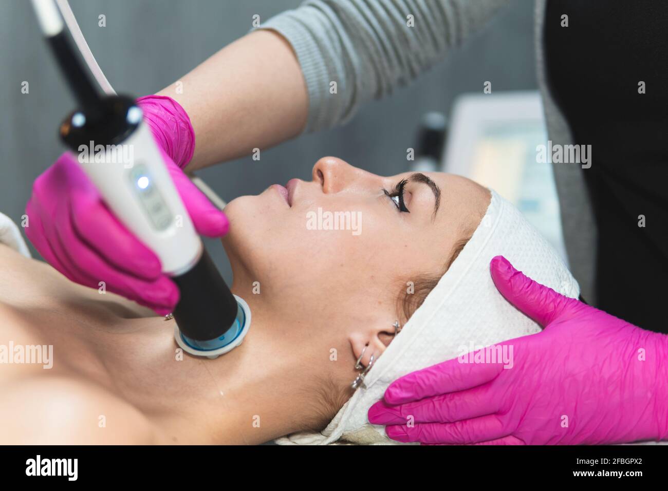 Head of young woman during skin treatment at aesthetic center Stock Photo