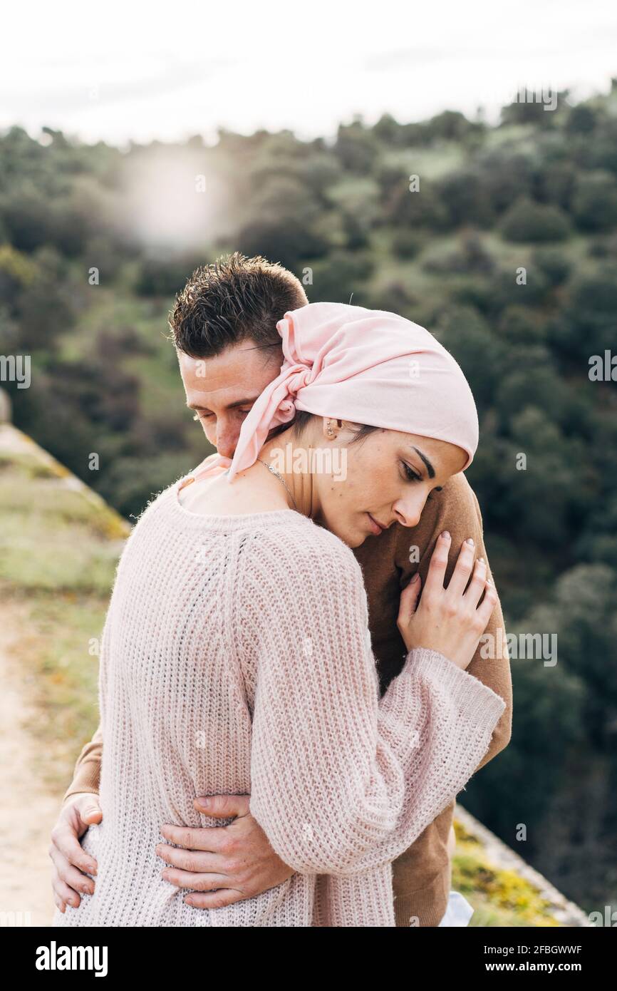 Girlfriend wearing bandana embracing boyfriend Stock Photo