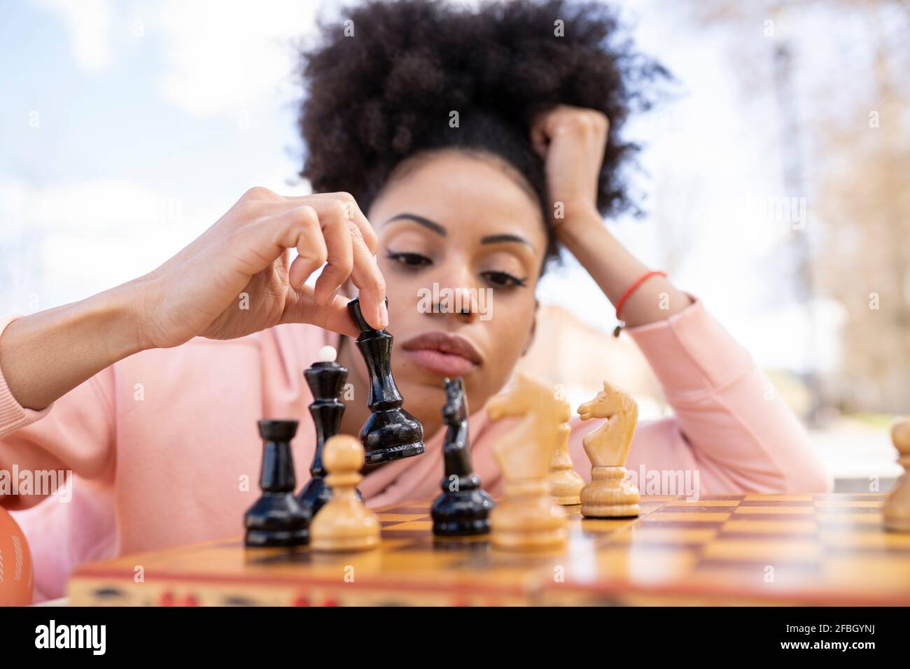 Pensive woman sitting at table in living room while thinking about next  chess move. Stock Photo by DC_Studio