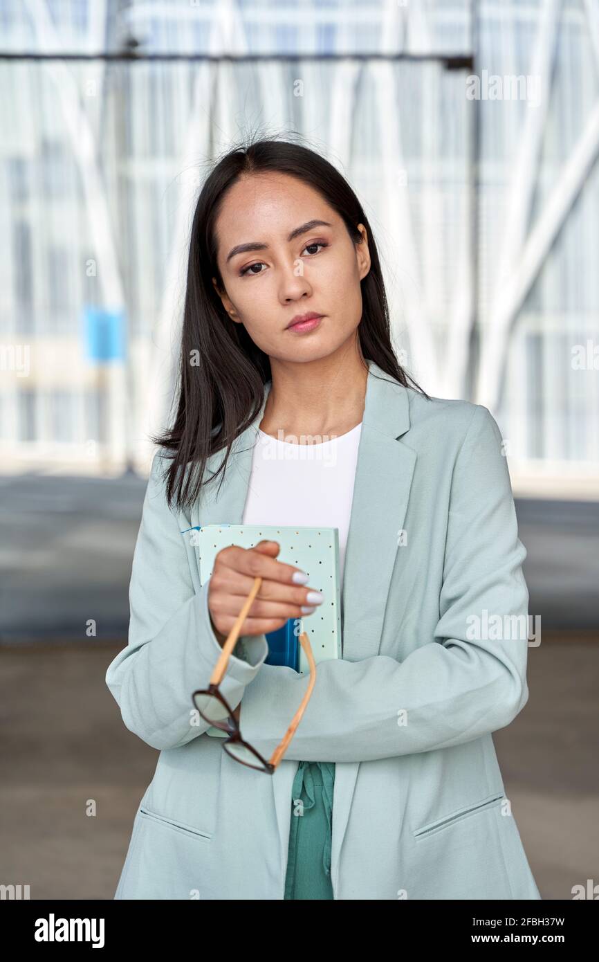 Businesswoman wearing blazer holding dairy and eyeglasses Stock Photo