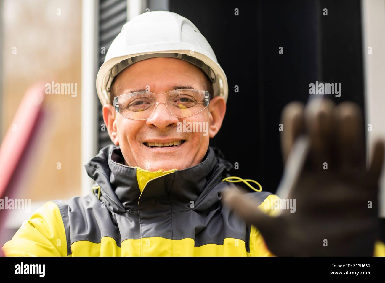Smiling male engineer gesturing while working Stock Photo