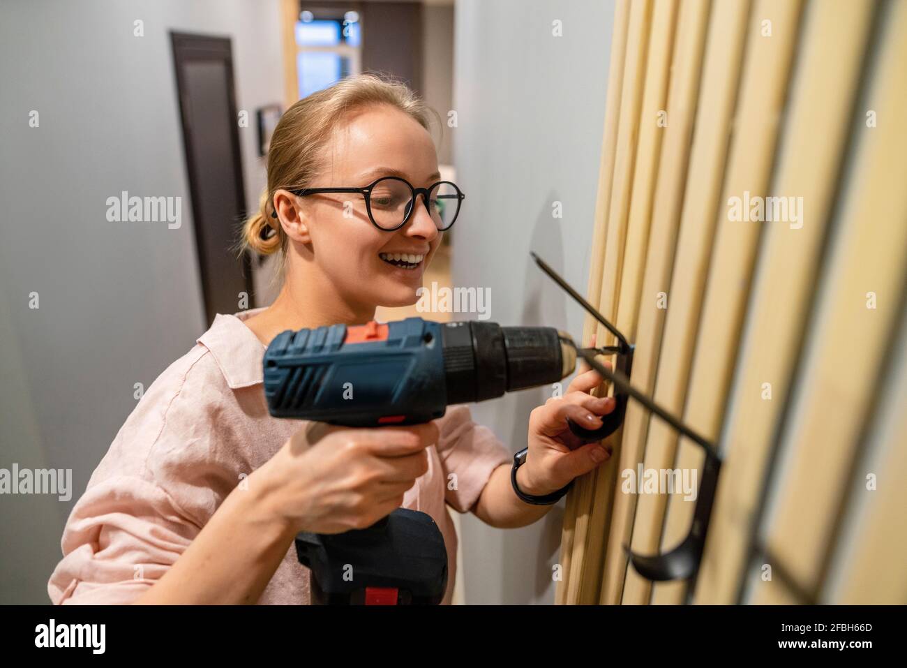 Young woman using drill machine hi res stock photography and