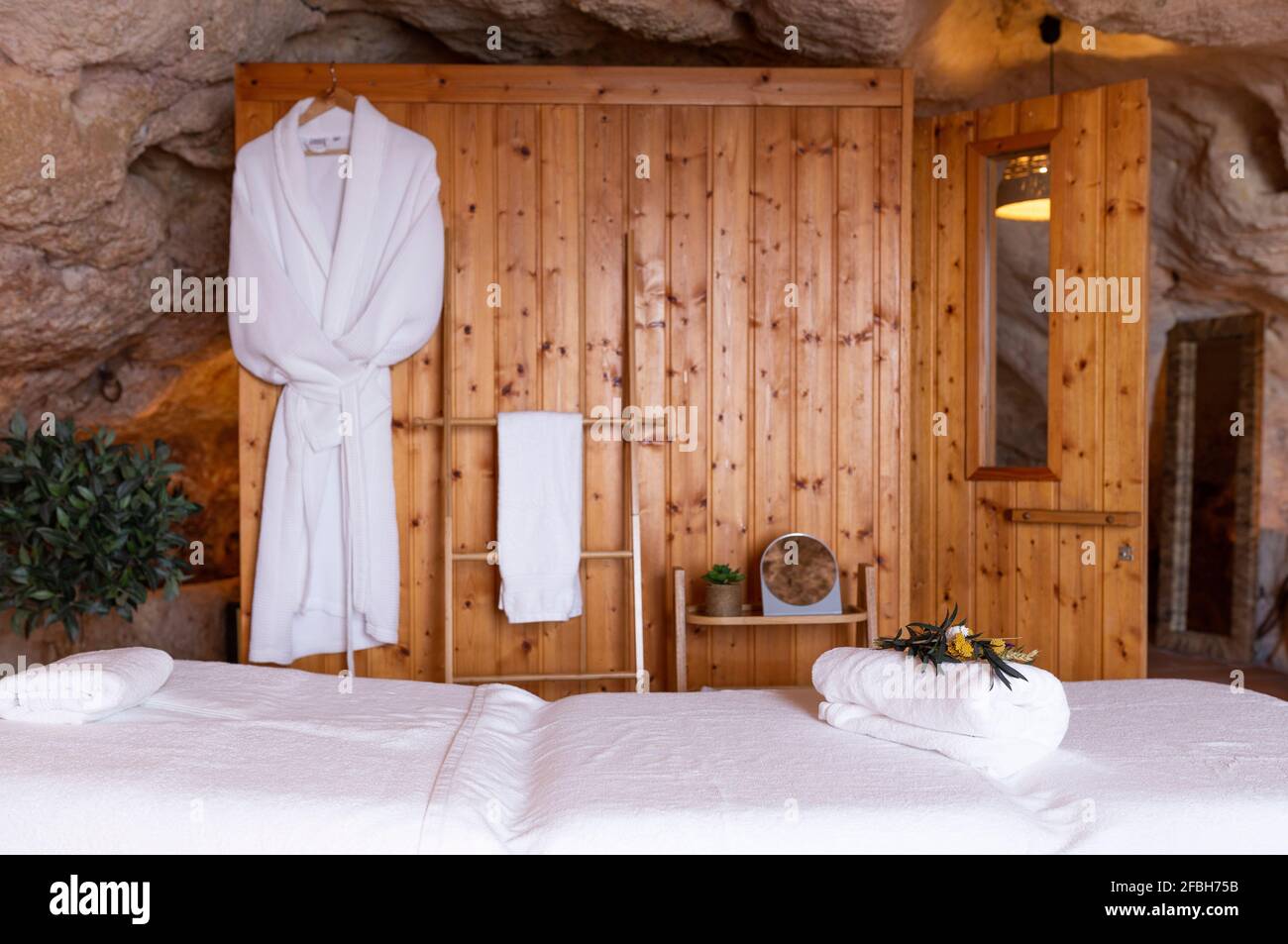 White bathrobe hanging on wooden wall in hotel room Stock Photo Alamy