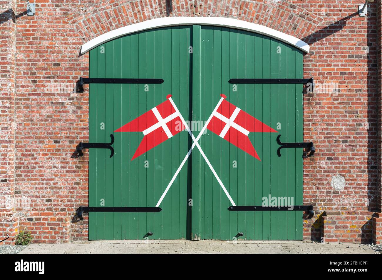 Denmark, Romo, Danish flags painted on wooden gate of fire station Stock Photo