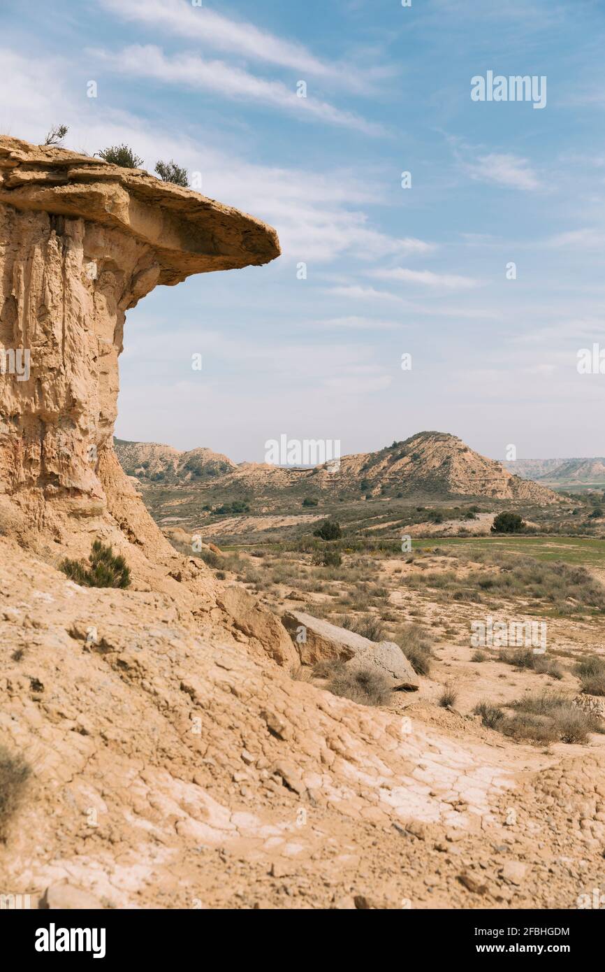 Sandstone rock formation in Monegros Desert with hills in background Stock Photo