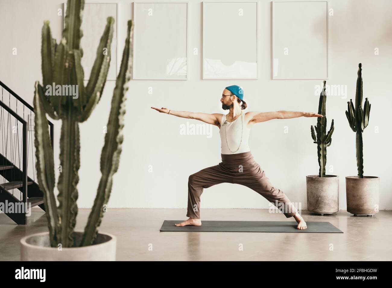 Male yoga teacher practicing with arms outstretched Stock Photo