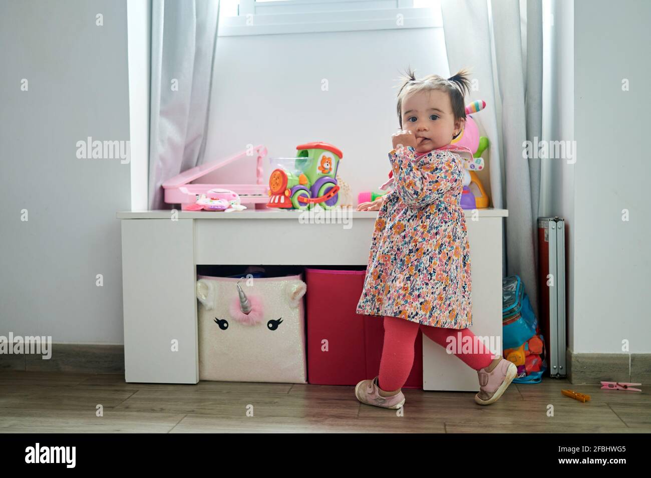 Cute girl standing by table in playroom at home Stock Photo