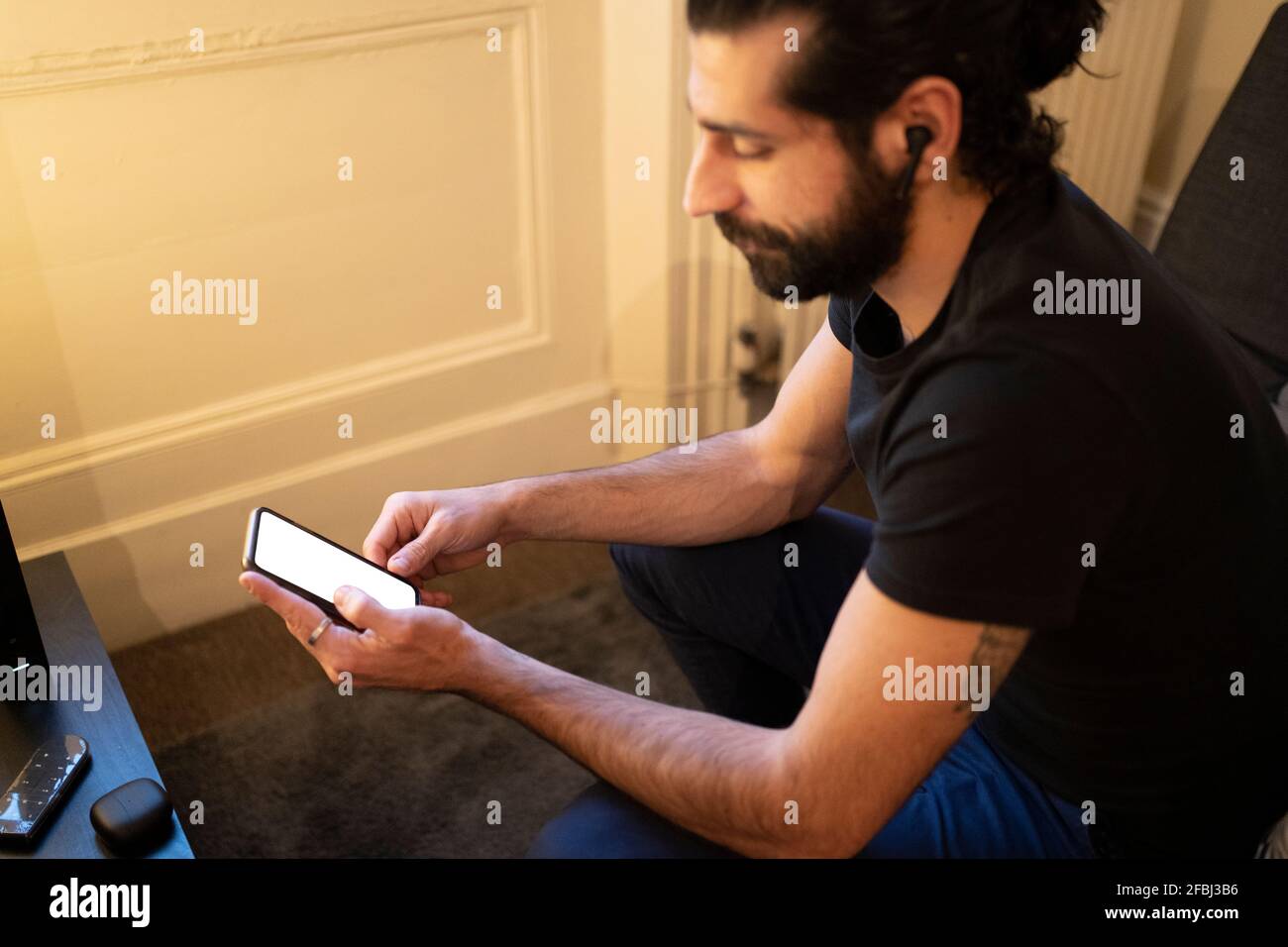 Young man using smart phone at home Stock Photo