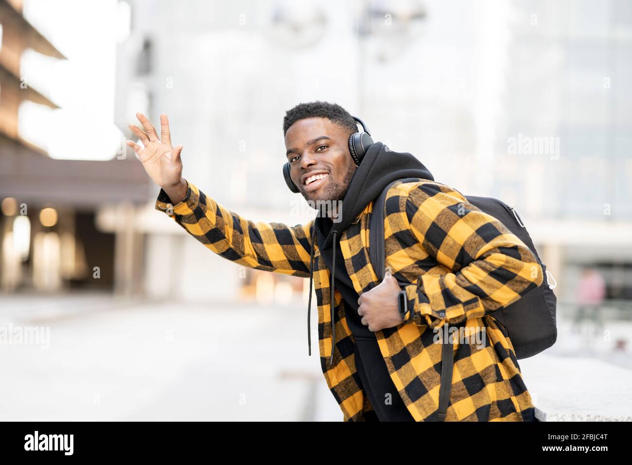 Smiling young African-American man hailing ride Stock Photo