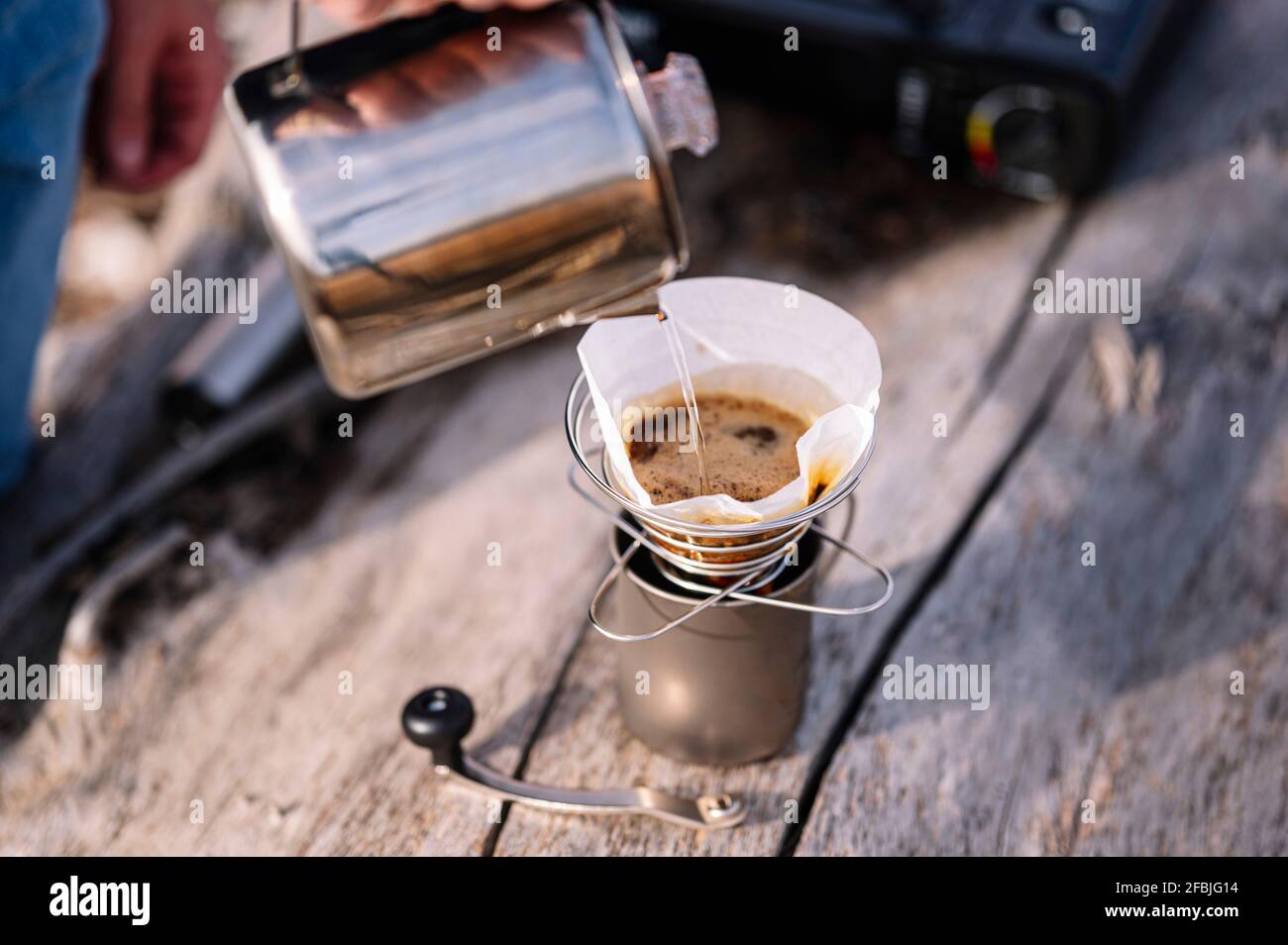 Man pouring water through kettle while preparing coffee Stock Photo