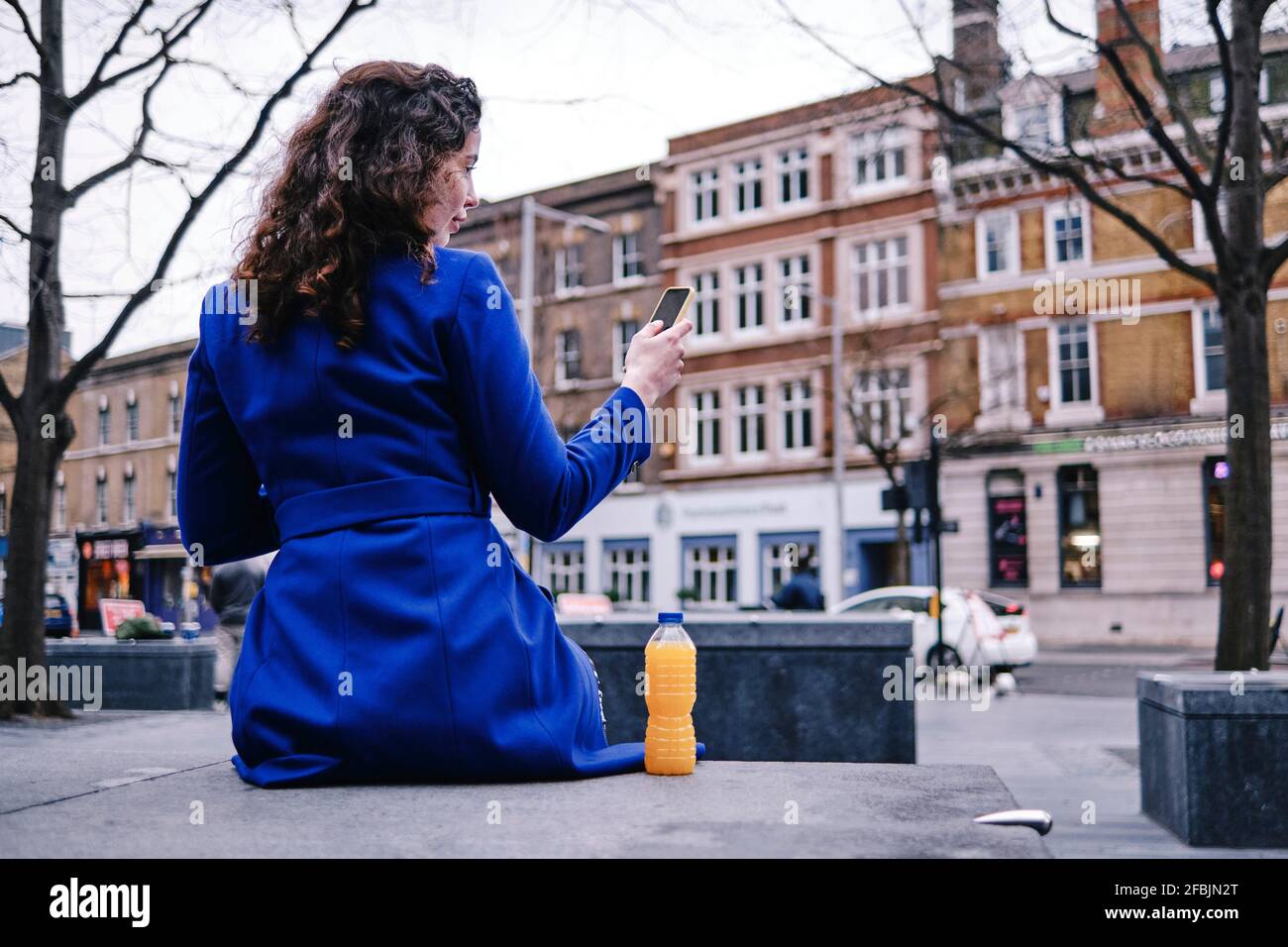 Female rear view mobile sitting hi-res stock photography and images - Alamy