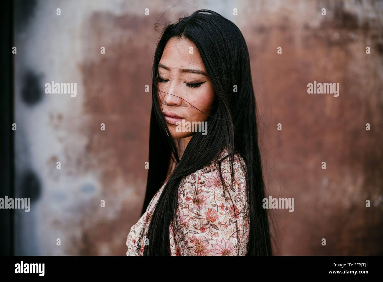 Beautiful woman with eyes closed by rusty iron door Stock Photo