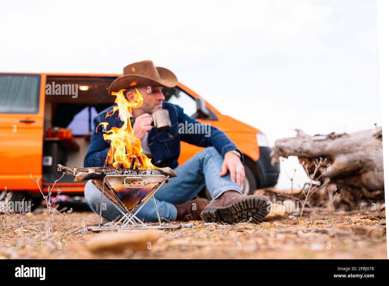 https://c8.alamy.com/comp/2FBJX78/mature-man-having-coffee-while-sitting-in-front-of-camping-stove-2FBJX78.jpg