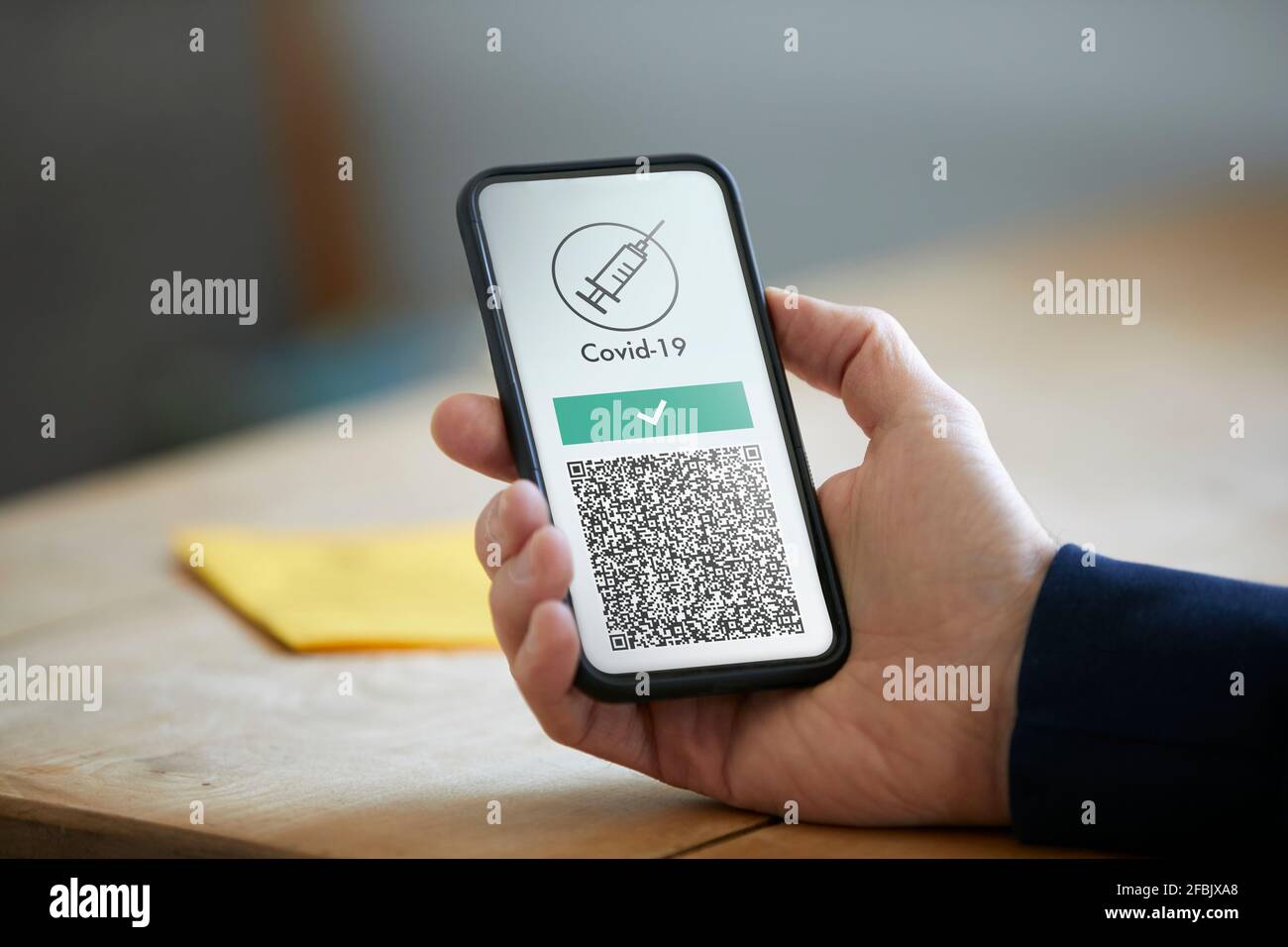 Man holding smart phone with COVID-19 vaccination QR code Stock Photo
