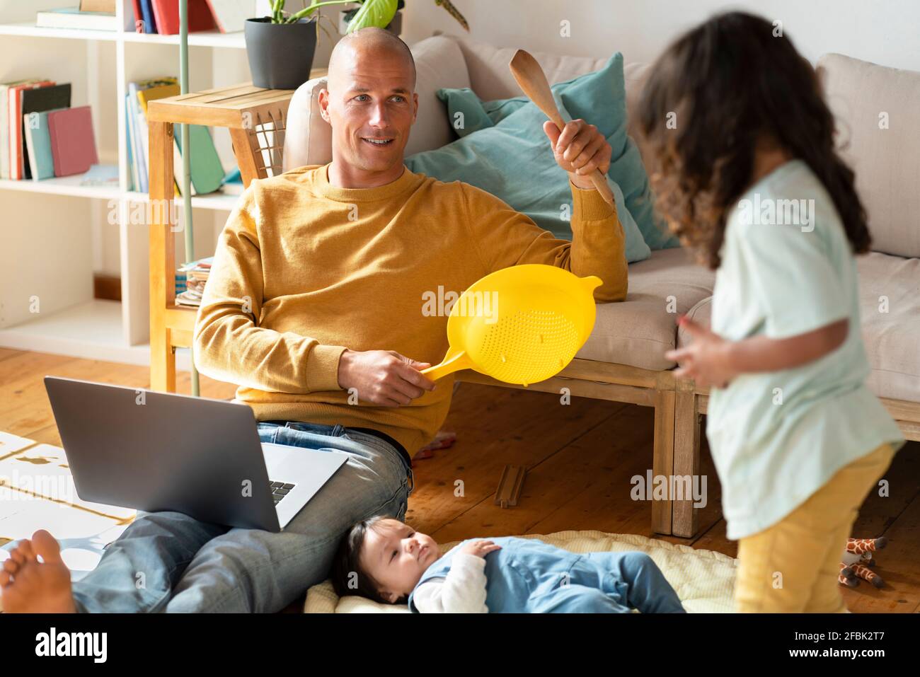 https://c8.alamy.com/comp/2FBK2T7/father-and-daughter-playing-with-kitchen-tools-while-baby-lying-at-home-2FBK2T7.jpg