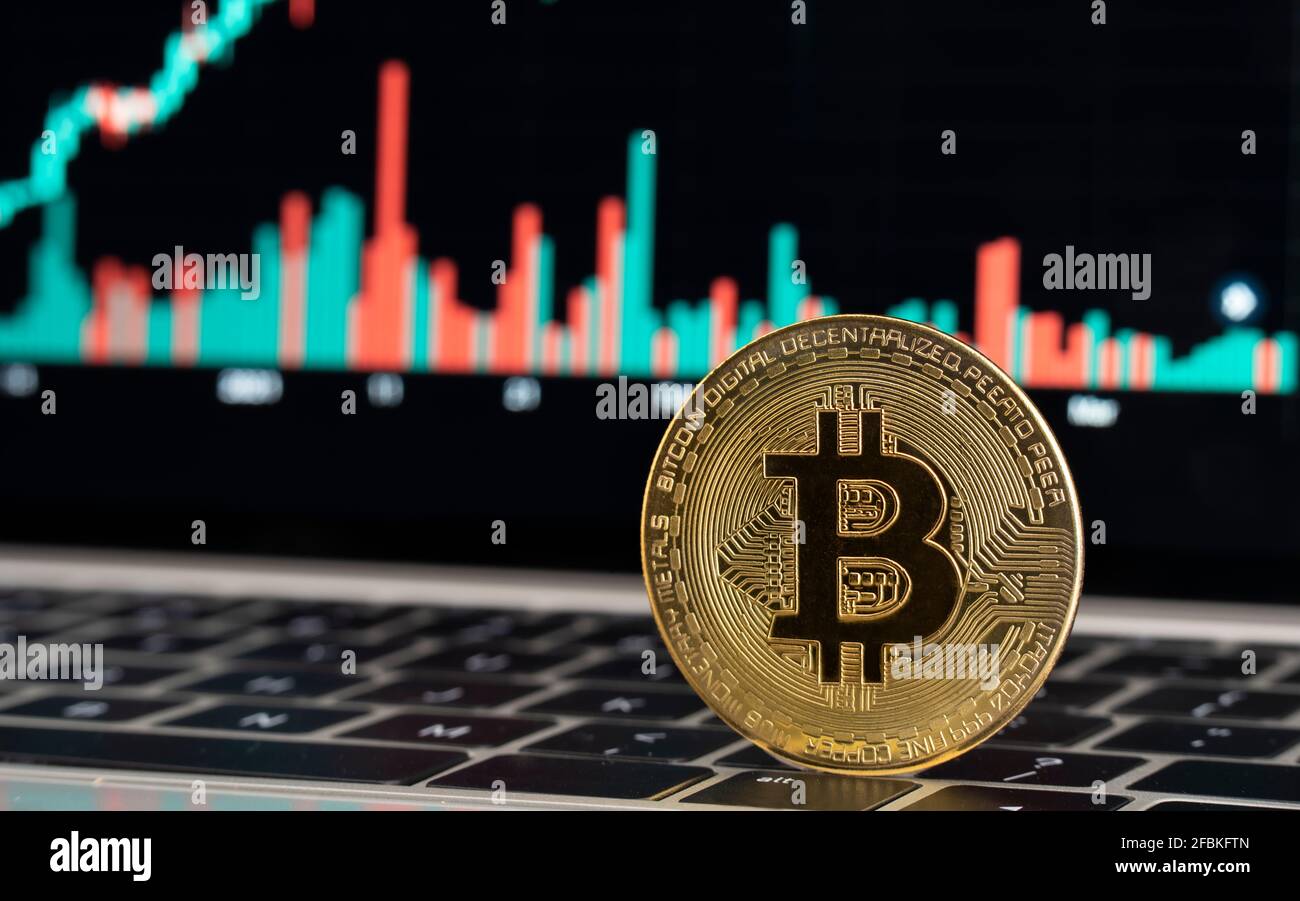 Gold colored bitcoin on laptop Stock Photo