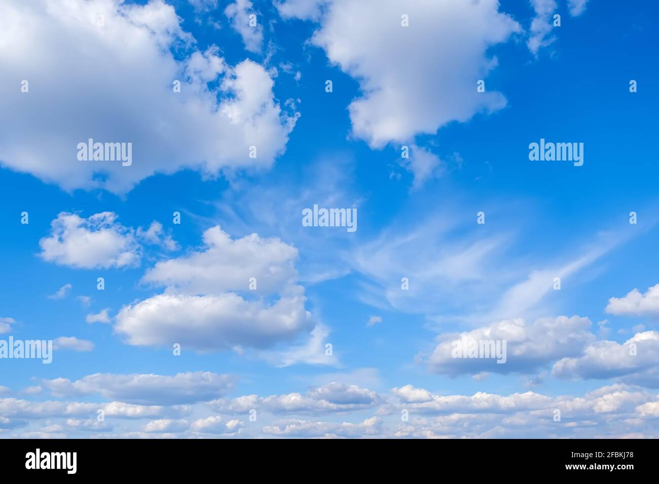 Blue sky with white fluffy clouds background Stock Photo - Alamy