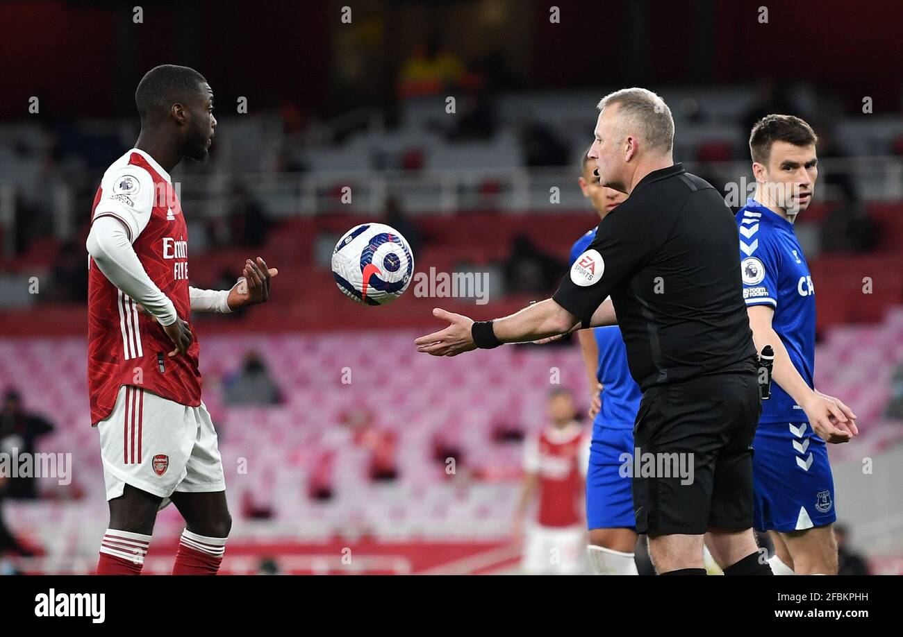 Referee Jonathan Moss collects the ball from Arsenal's Nicolas Pepe after the penalty decision is overturned by VAR during the Premier League match at the Emirates Stadium, London. Picture date: Friday April 23, 2021. Stock Photo