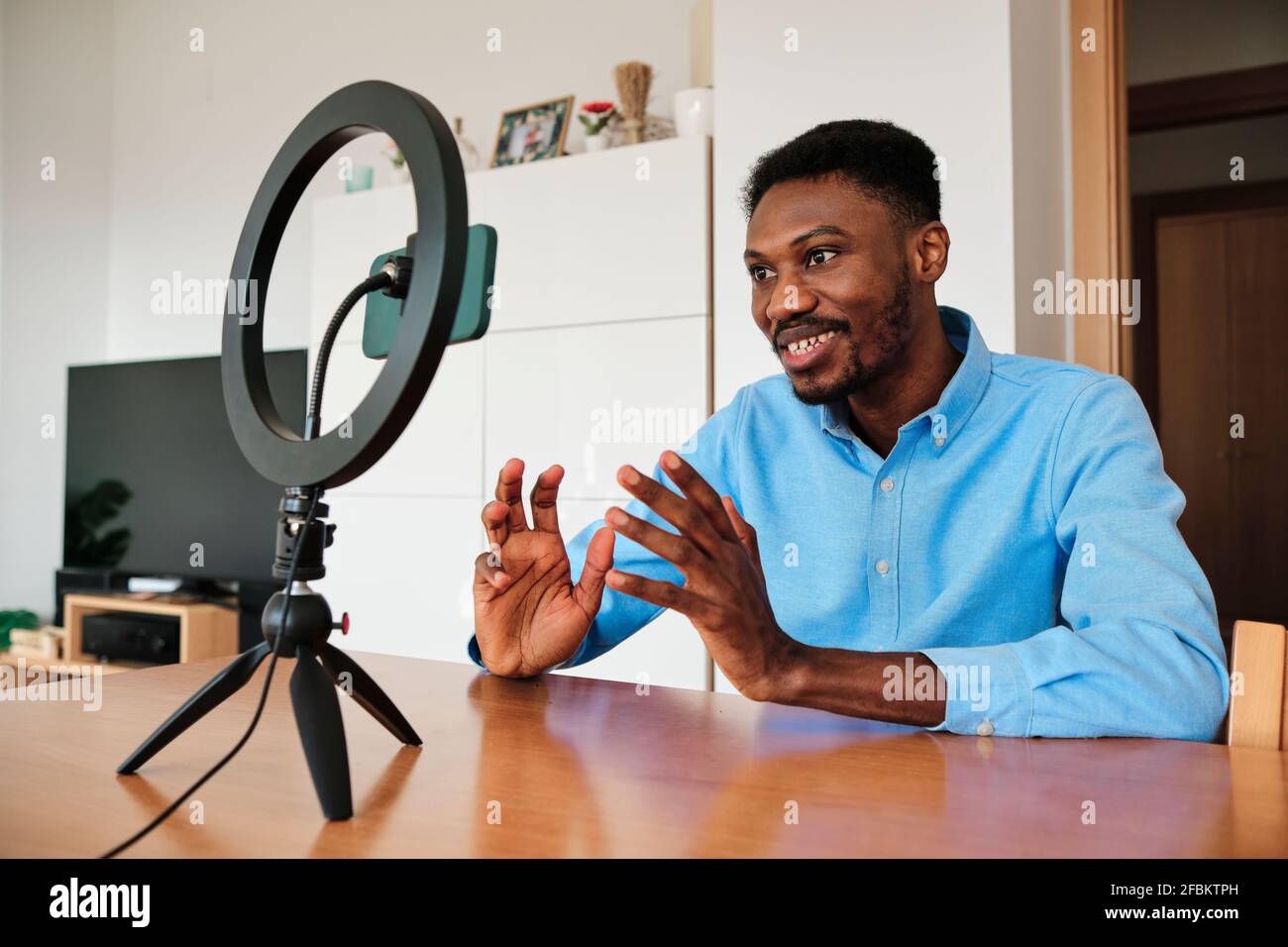 Male influencer vlogging through mobile phone with ring light at home Stock  Photo - Alamy