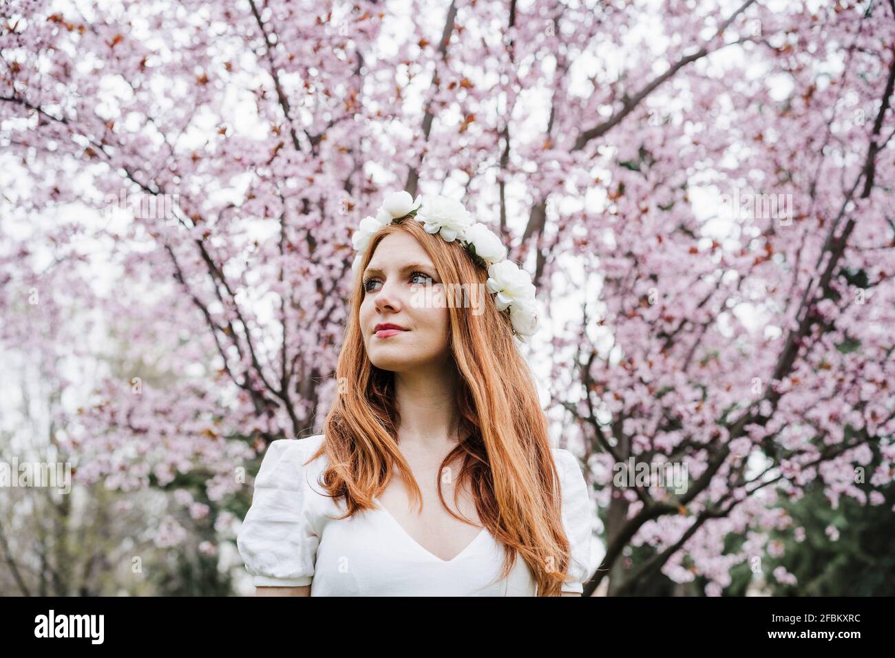 Beautiful woman wearing white flower tiara looking away Stock Photo