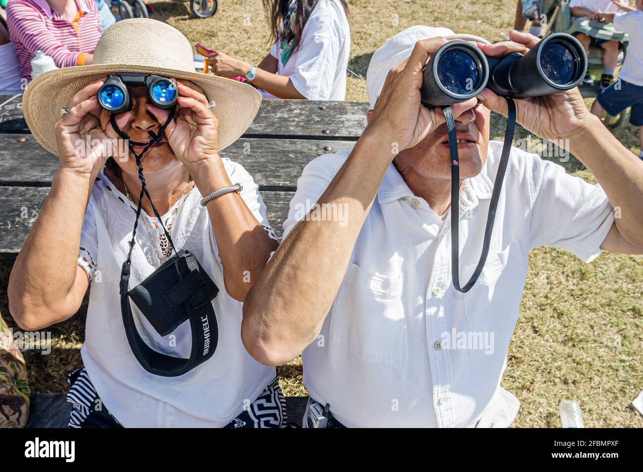 Miami Beach Florida,Haulover Beach Park Kite Day Festival,grandparents senior seniors couple through using binoculars,man woman, Stock Photo