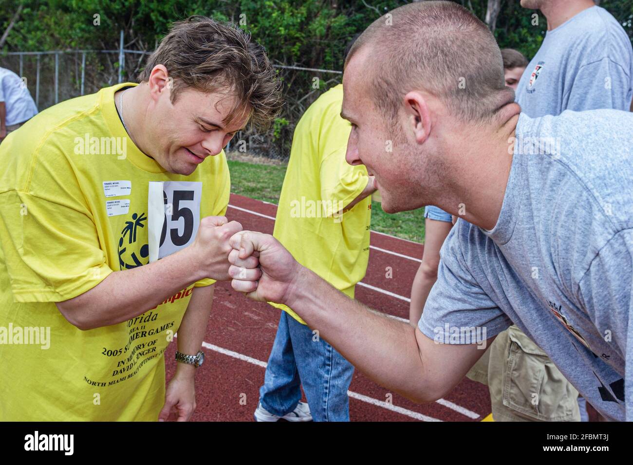 Florida North Miami FIU campus Special Olympics Summer Games,mentally disabled adult volunteer coach man men male fist bump, Stock Photo