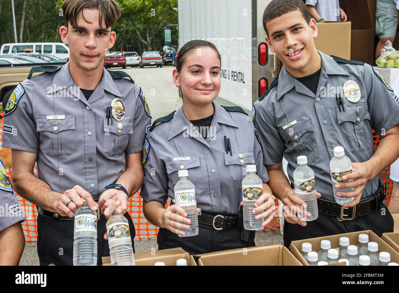 Florida North Miami FIU campus Special Olympics Summer Games,volunteers police Explorers offering handing out free bottled water,Hispanic teen teenage Stock Photo