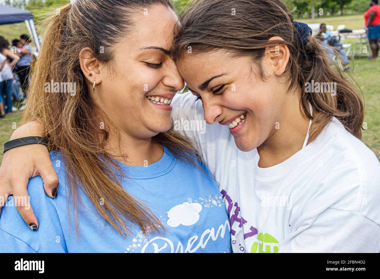 Miami Florida,Tropical Park Drug Free Youth In Town picnic,Hispanic mother parent daughter girl hugging smiling family Stock Photo