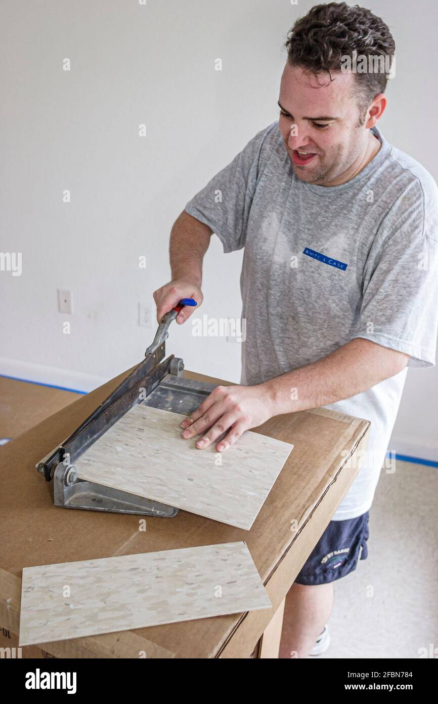 Miami Florida,Liberty City Habitat For Humanity,volunteer working man new construction home site building cutting tile, Stock Photo